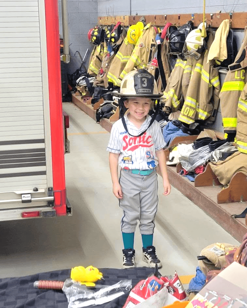 A young visitor tries on a firefighter helmet at Station 1
